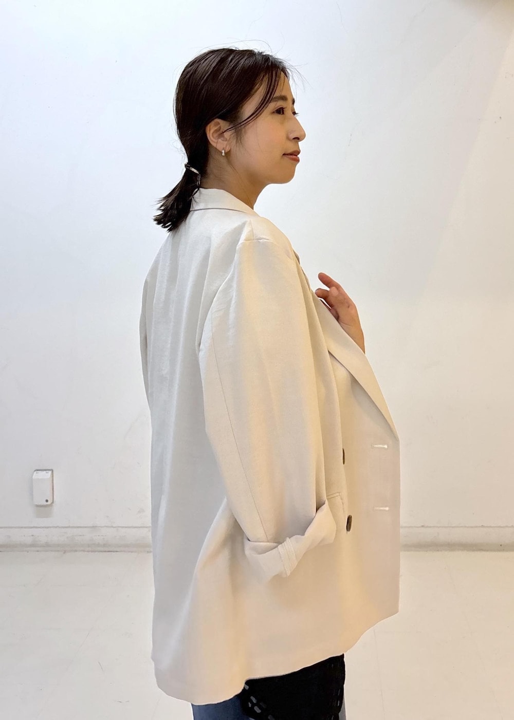 ベージュ系のショルダーバッグ、ホワイト系のテーラードジャケット、レッド系のパンプスを着用したレディースの夏コーディネートの6枚目の写真