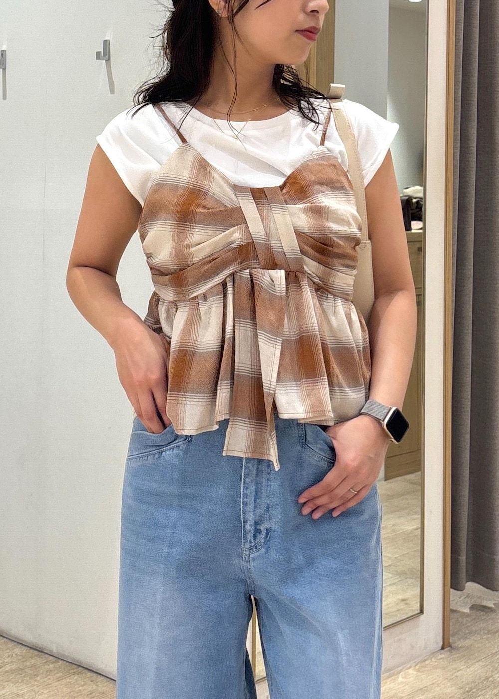 ブラック系のサンダル、ホワイト系のショルダーバッグ、ブルー系のデニムパンツを着用したレディースの夏コーディネートの5枚目の写真