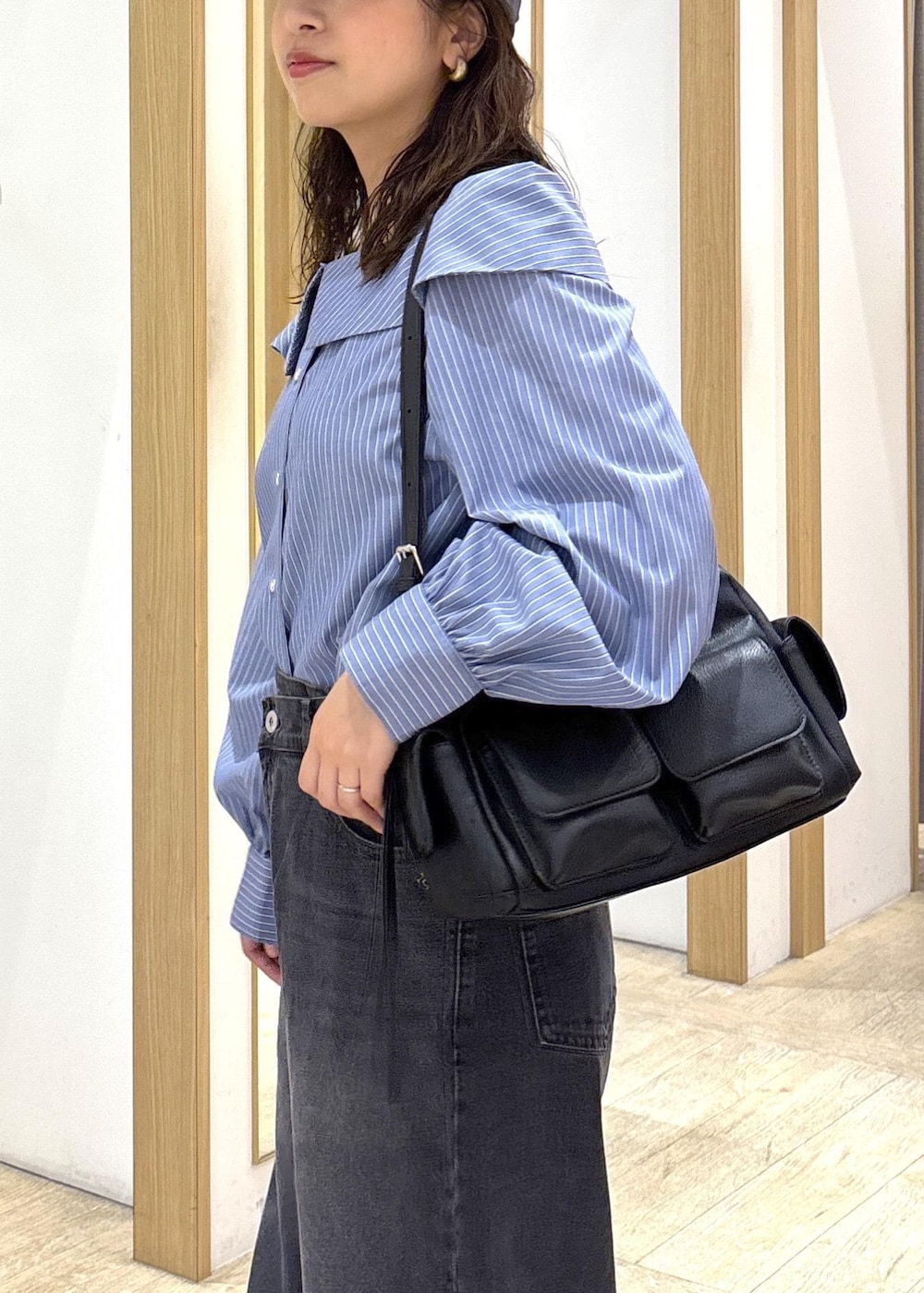 ブラック系のショルダーバッグ、ブラック系のローファー、ブルー系のシャツ/ブラウスを着用したレディースの秋コーディネートの6枚目の写真