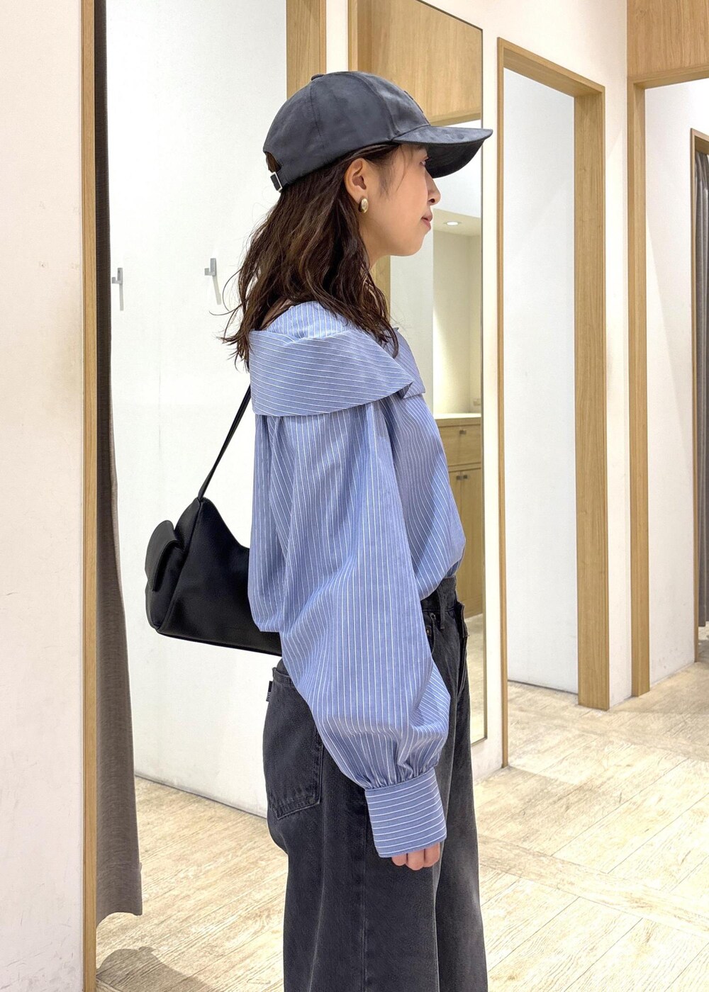 ブラック系のショルダーバッグ、ブラック系のローファー、ブルー系のシャツ/ブラウスを着用したレディースの秋コーディネートの8枚目の写真