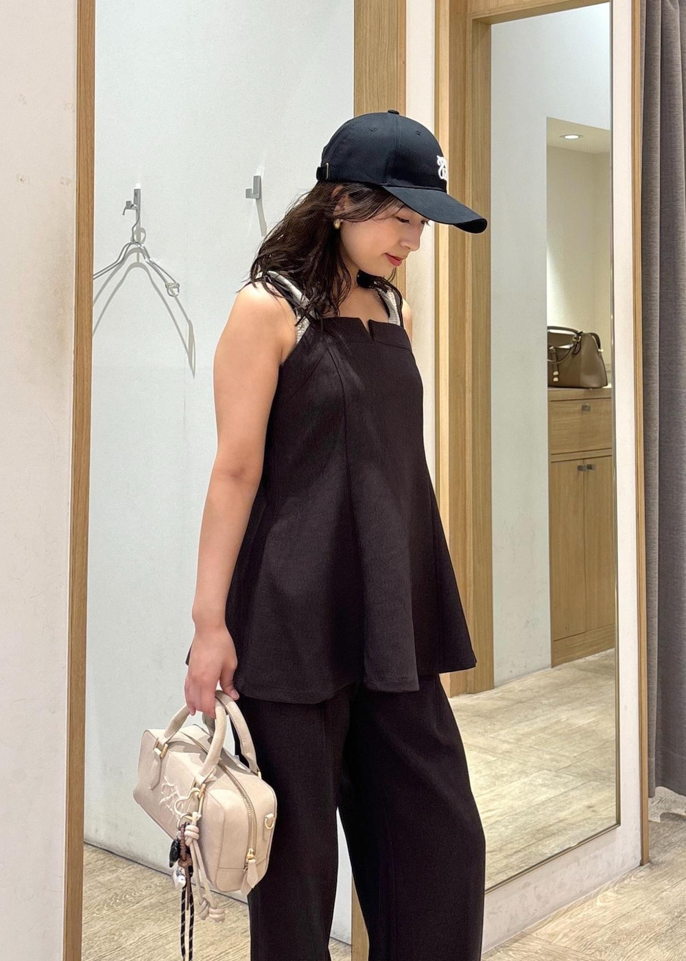 ベージュ系のボストンバッグ、ブラウン系のスラックス、ブラウン系のキャミソールを着用したレディースの秋コーディネートの6枚目の写真