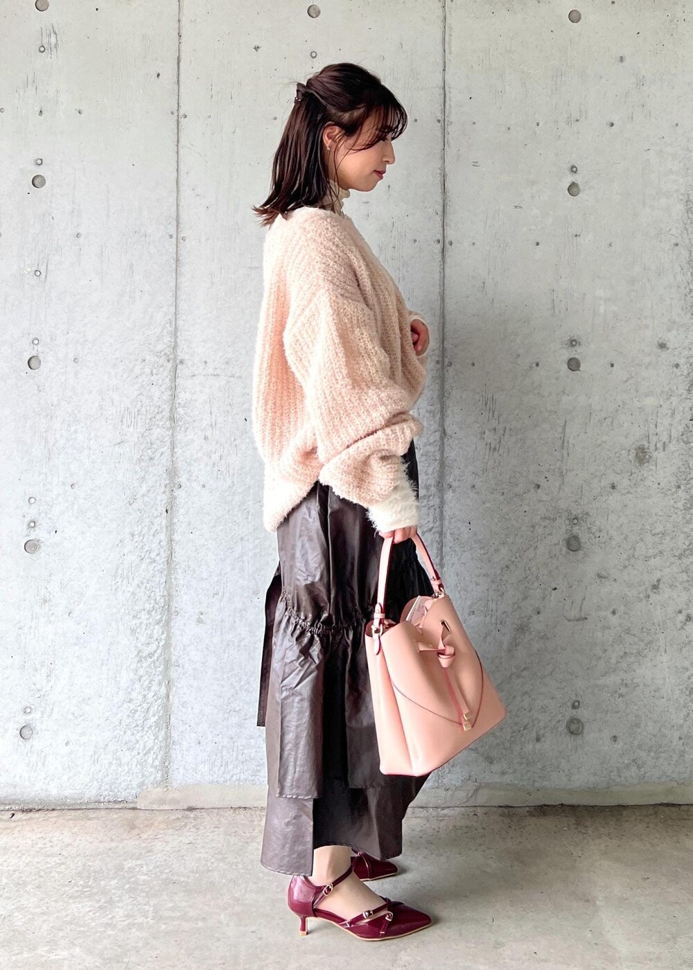 ピンク系のショルダーバッグ、ホワイト系のニット/セーター、ベージュ系のニット/セーターを着用したレディースの冬コーディネートの5枚目の写真