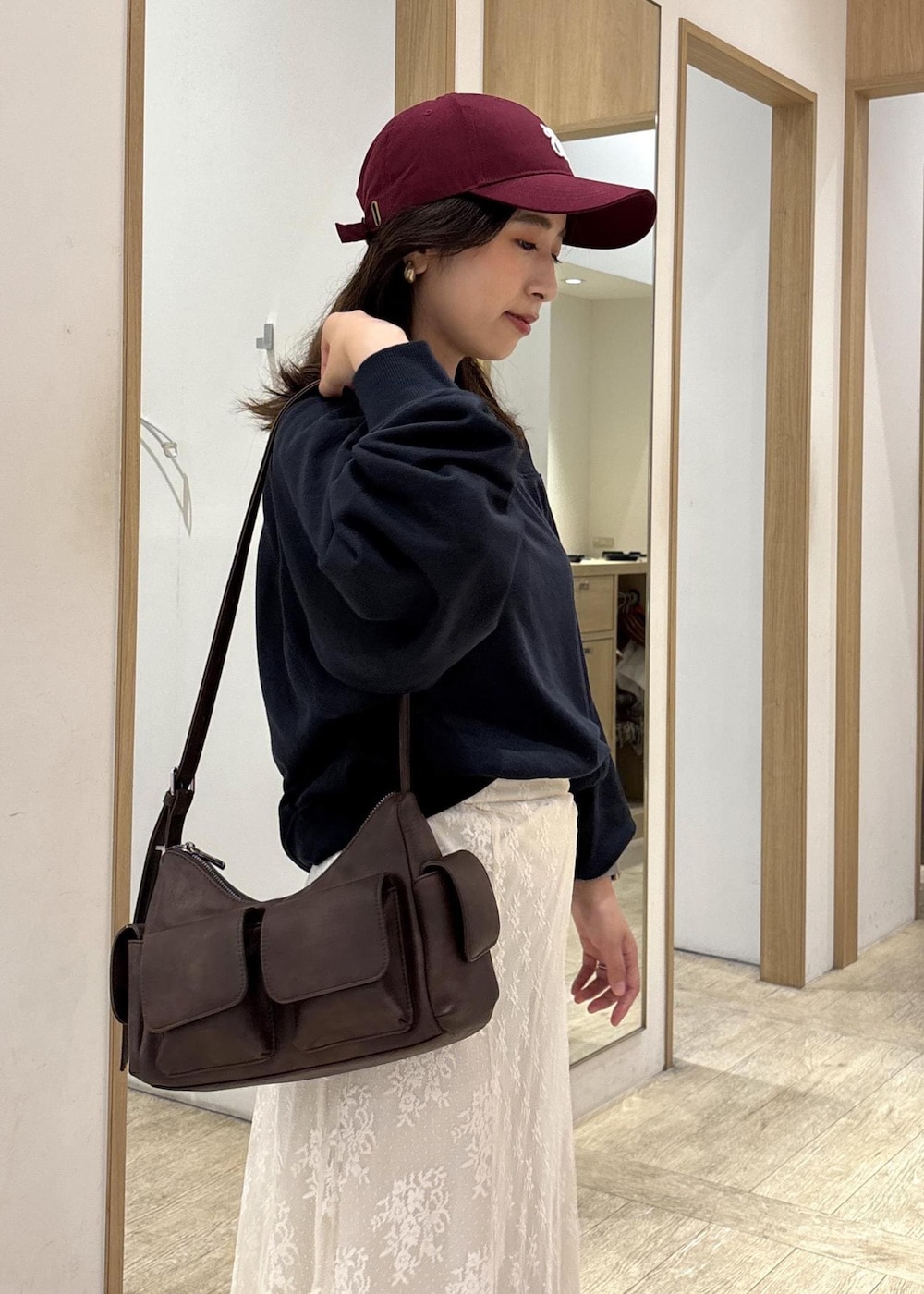 ブラウン系のショルダーバッグ、ベージュ系のローファー、ホワイト系のスカートを着用したレディースの秋コーディネートの9枚目の写真