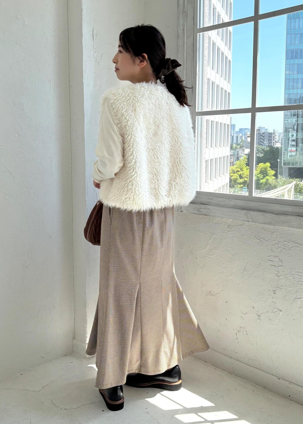 ブラック系のローファー、ベージュ系のスカート、ホワイト系のTシャツ/カットソーを着用したレディースの夏コーディネートの3枚目の写真