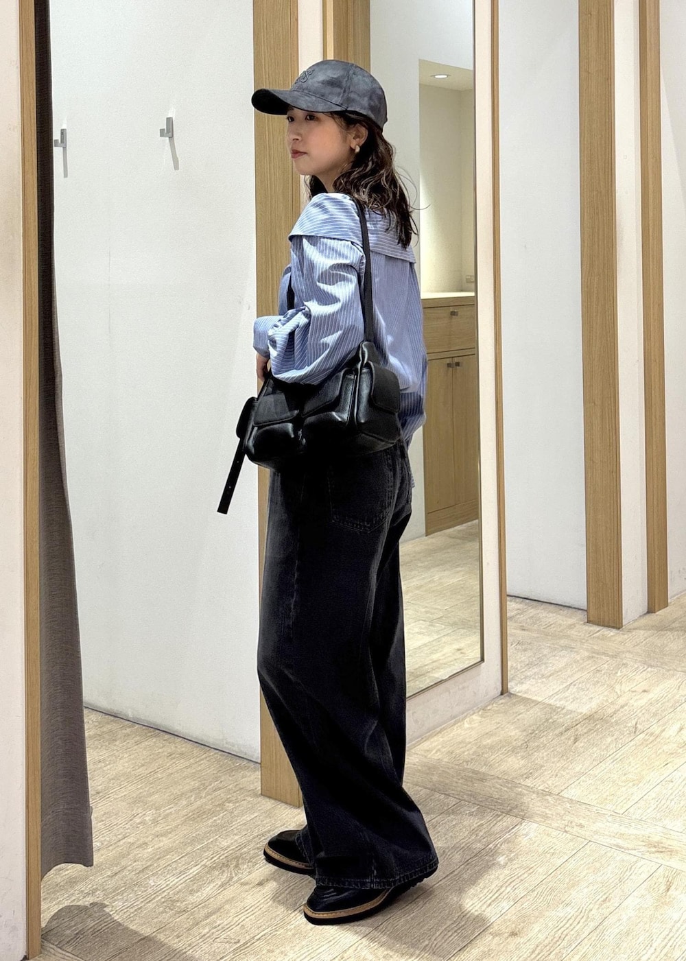 ブラック系のショルダーバッグ、ブラック系のローファー、ブルー系のシャツ/ブラウスを着用したレディースの秋コーディネートの2枚目の写真