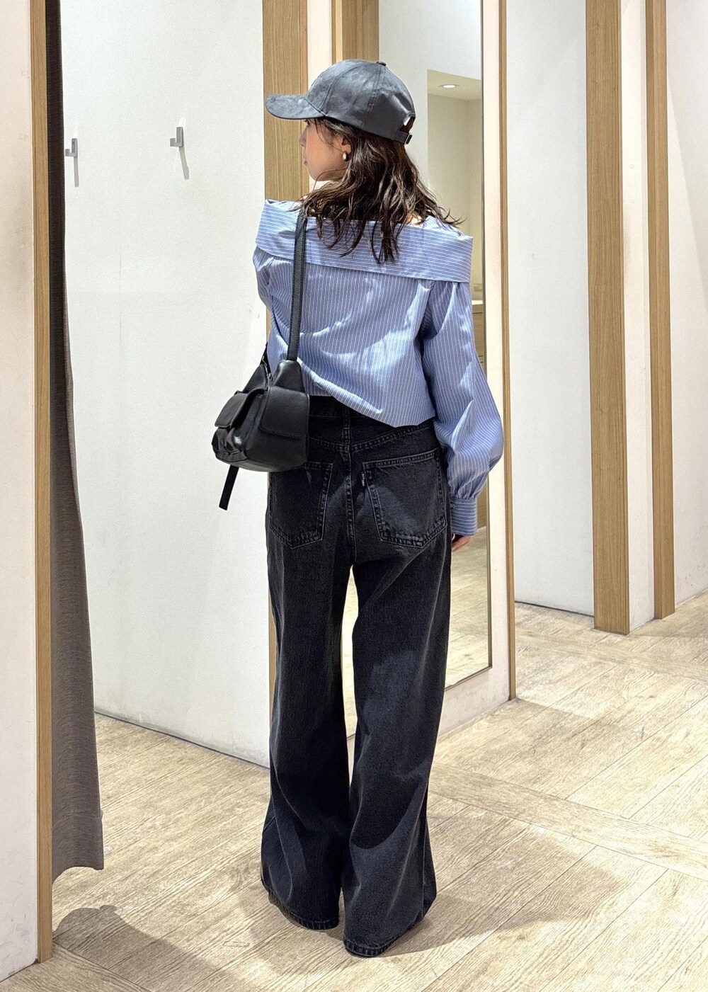 ブラック系のショルダーバッグ、ブラック系のローファー、ブルー系のシャツ/ブラウスを着用したレディースの秋コーディネートの3枚目の写真