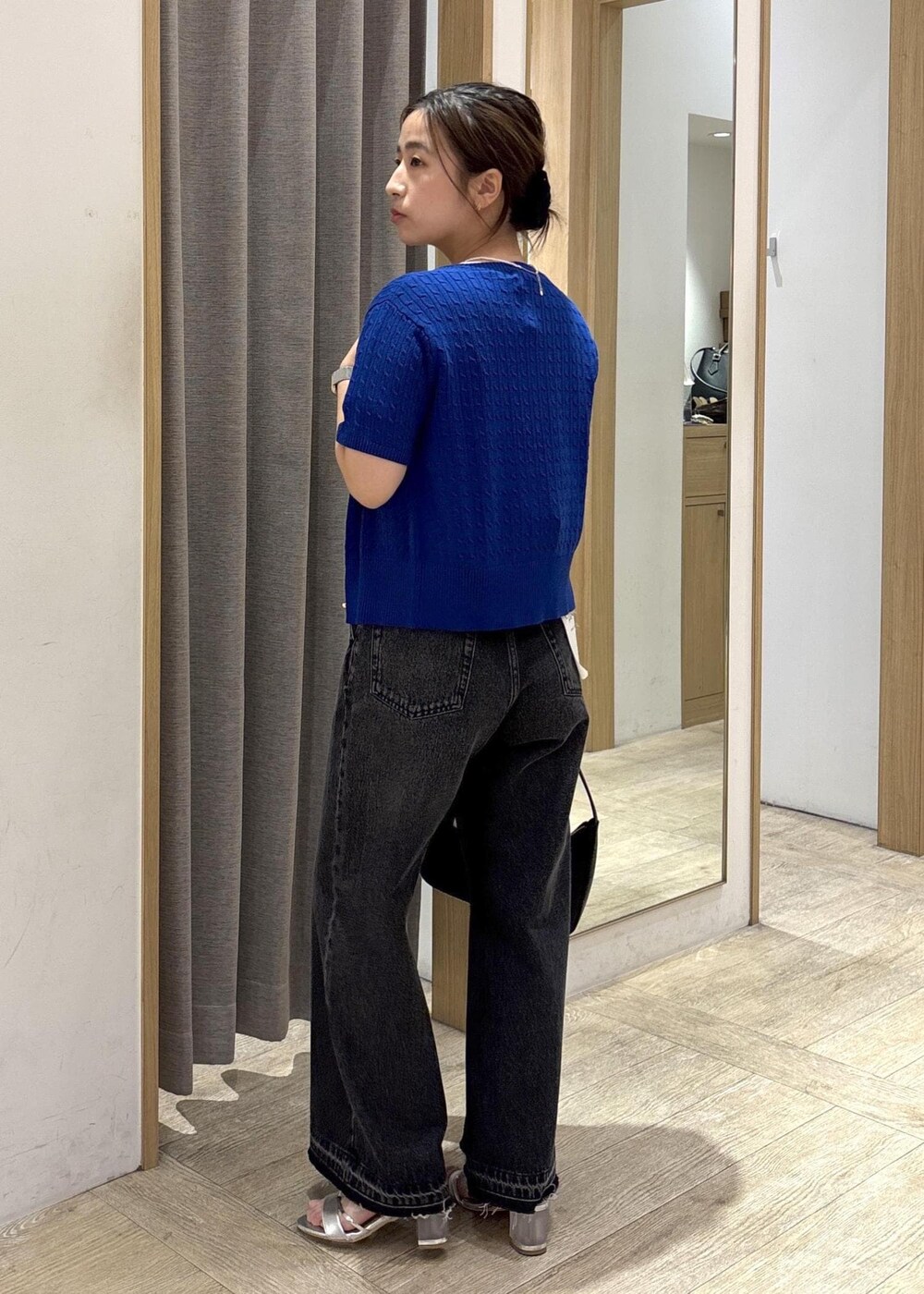 ブラック系のショルダーバッグ、ブラック系のデニムパンツ、ホワイト系のTシャツ/カットソーを着用したレディースの春コーディネートの3枚目の写真