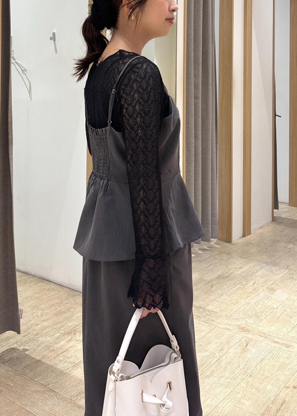 ホワイト系のショルダーバッグ、ブラック系のパンプス、グレー系のワンピースを着用したレディースの秋コーディネートの5枚目の写真