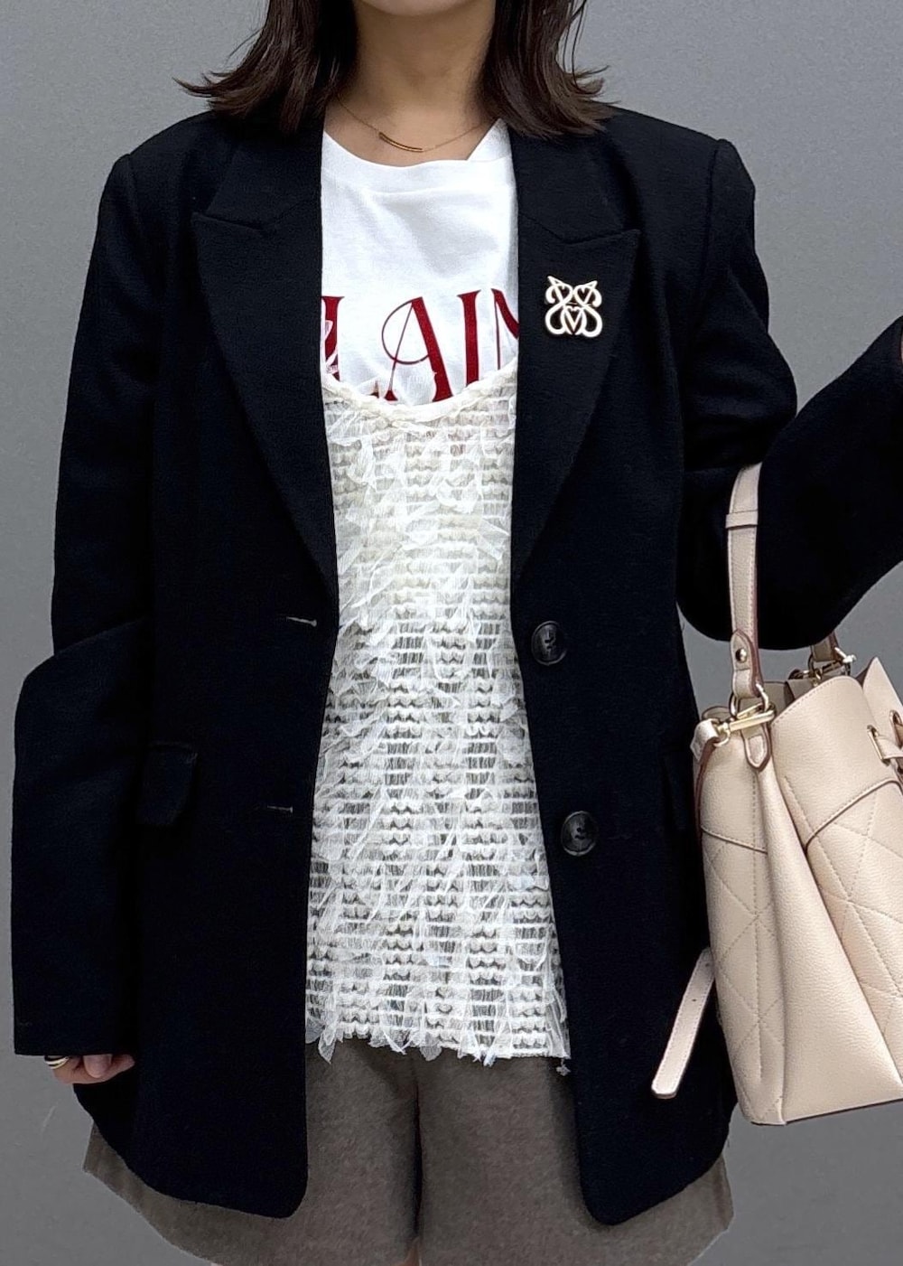 ブラック系のブーツ、ベージュ系のショルダーバッグ、ホワイト系のTシャツ/カットソーを着用したレディースの秋コーディネートの5枚目の写真