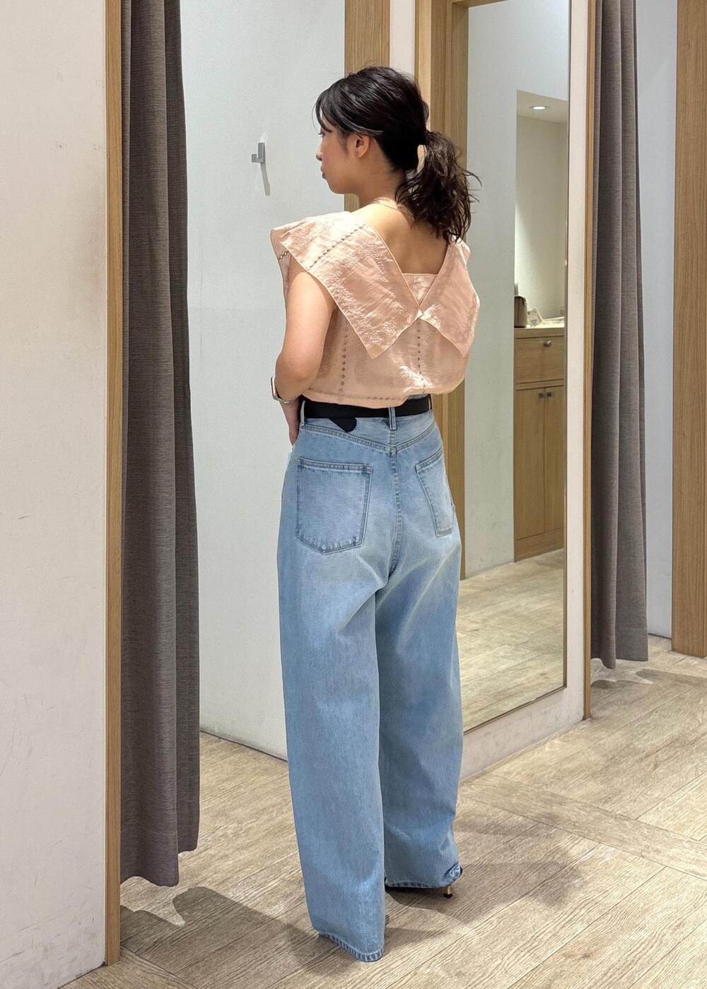 ブルー系のデニムパンツ、ブラック系のサンダル、ブラック系のショルダーバッグを着用したレディースの夏コーディネートの2枚目の写真