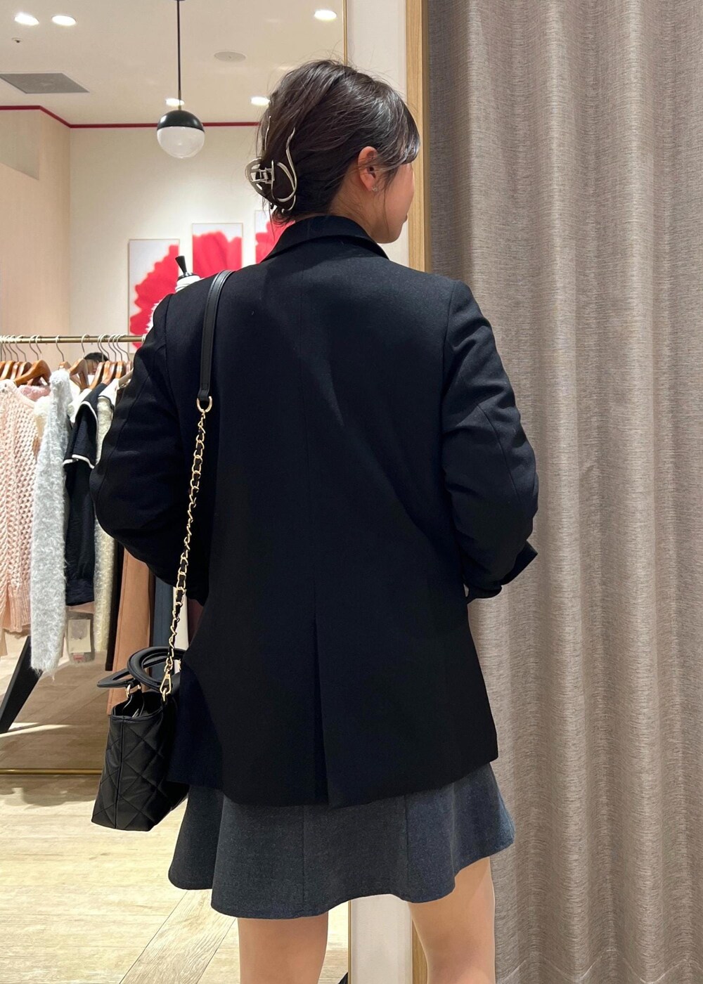 ブラック系のテーラードジャケット、ブラック系のスニーカー、ブルー系のカーディガン/ボレロを着用したレディースの冬コーディネートの9枚目の写真