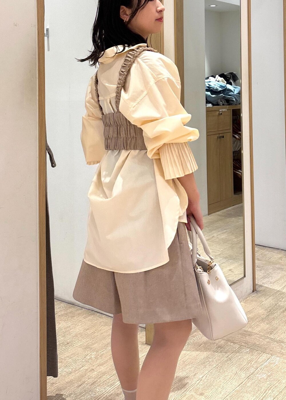 ホワイト系のショルダーバッグ、イエロー系のその他パンツ、イエロー系のベストを着用したレディースの春コーディネートの7枚目の写真