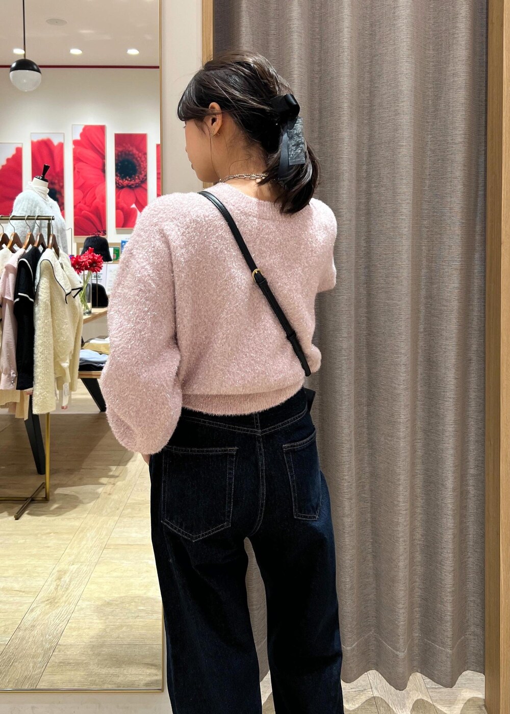 ブラック系のショルダーバッグ、シルバー系のブーツ、ブルー系のデニムパンツを着用したレディースの冬コーディネートの8枚目の写真
