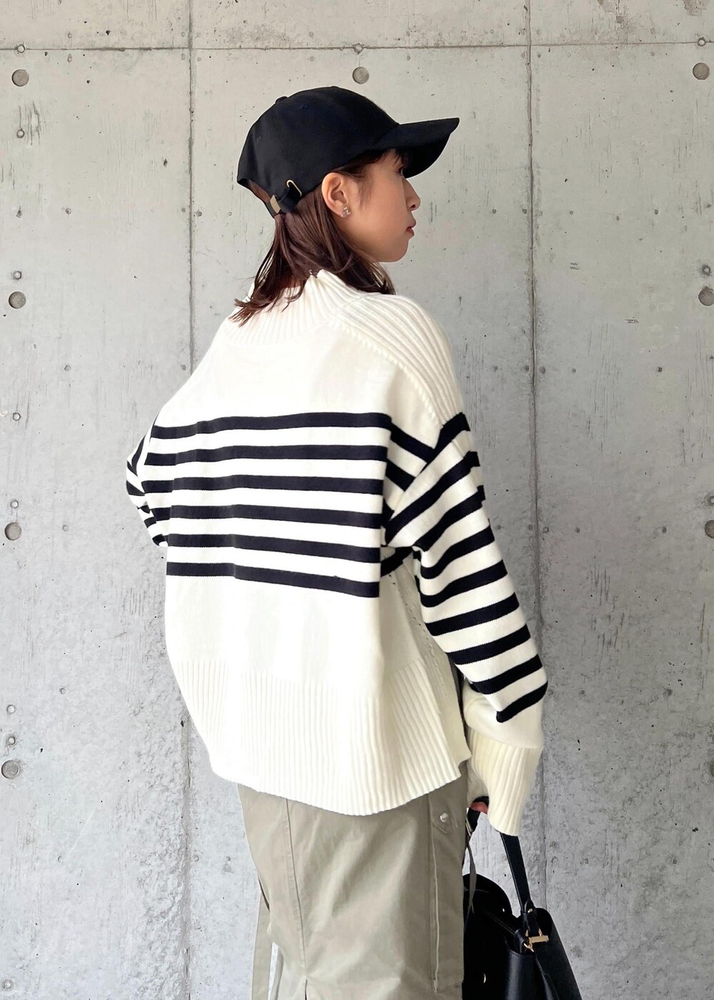 ブラック系のブーツ、グリーン系のスカート、ホワイト系のニット/セーターを着用したレディースの秋コーディネートの9枚目の写真