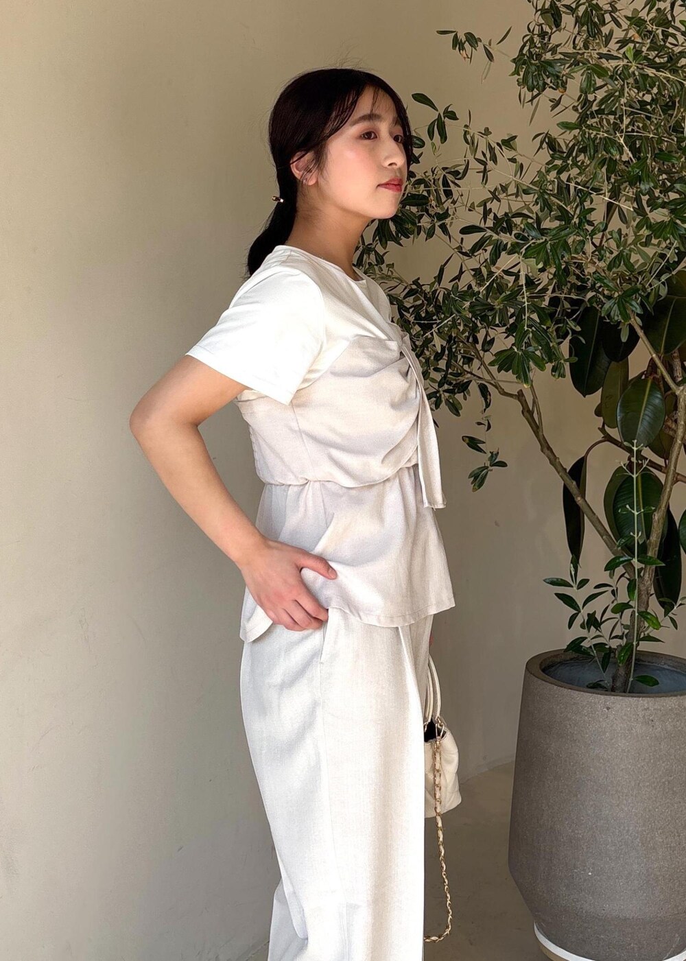 ホワイト系のパンプス、ホワイト系のTシャツ/カットソー、ホワイト系のスラックスを着用したレディースの春コーディネートの8枚目の写真