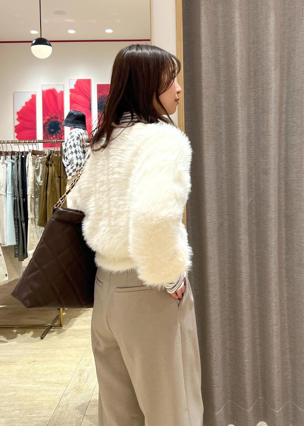 ベージュ系のスラックス、ホワイト系のカーディガン/ボレロ、ブラウン系のショルダーバッグを着用したレディースの冬コーディネートの8枚目の写真