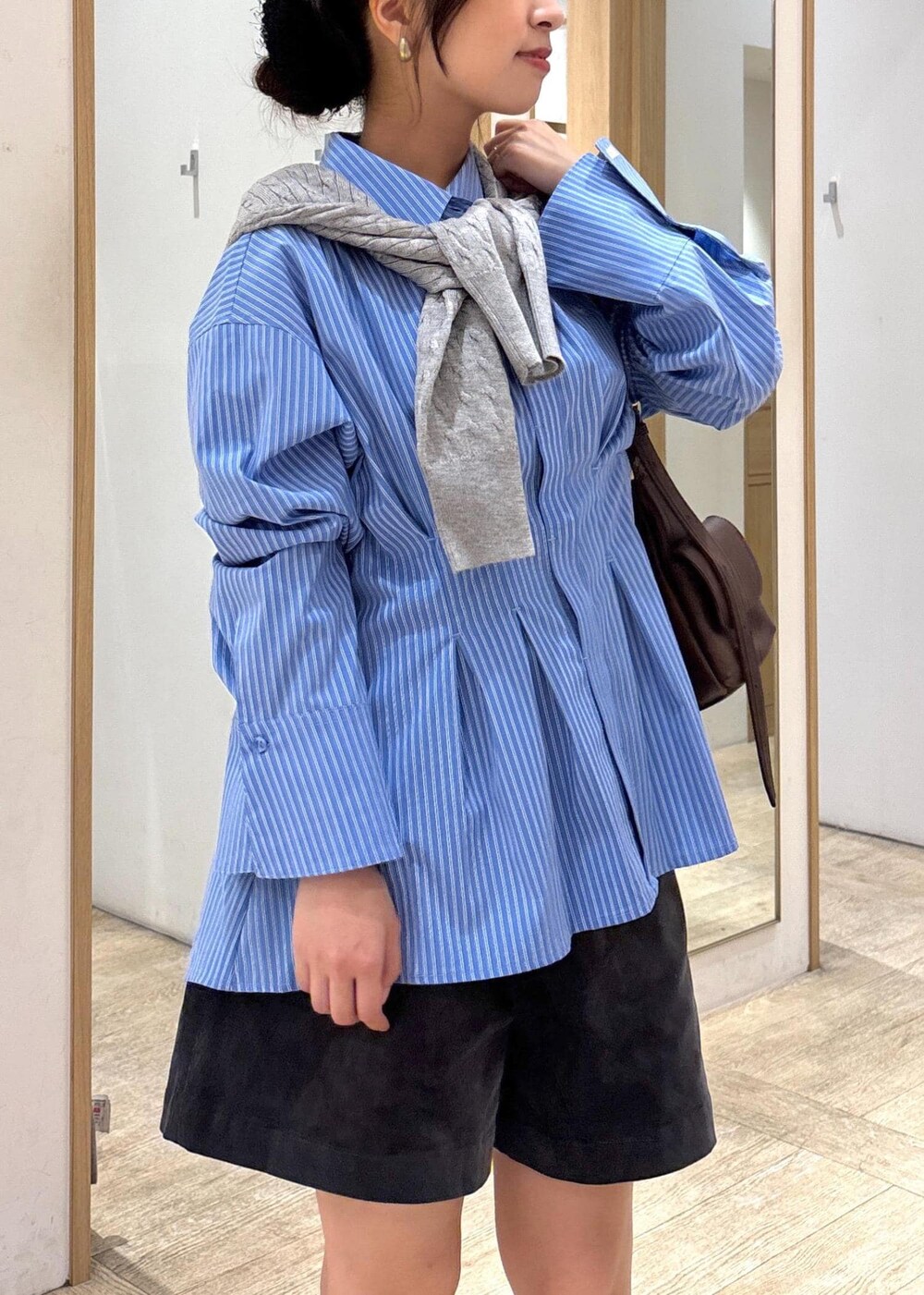 ブラック系のブーツ、ブルー系のシャツ/ブラウス、グレー系のカーディガン/ボレロを着用したレディースの秋コーディネートの6枚目の写真