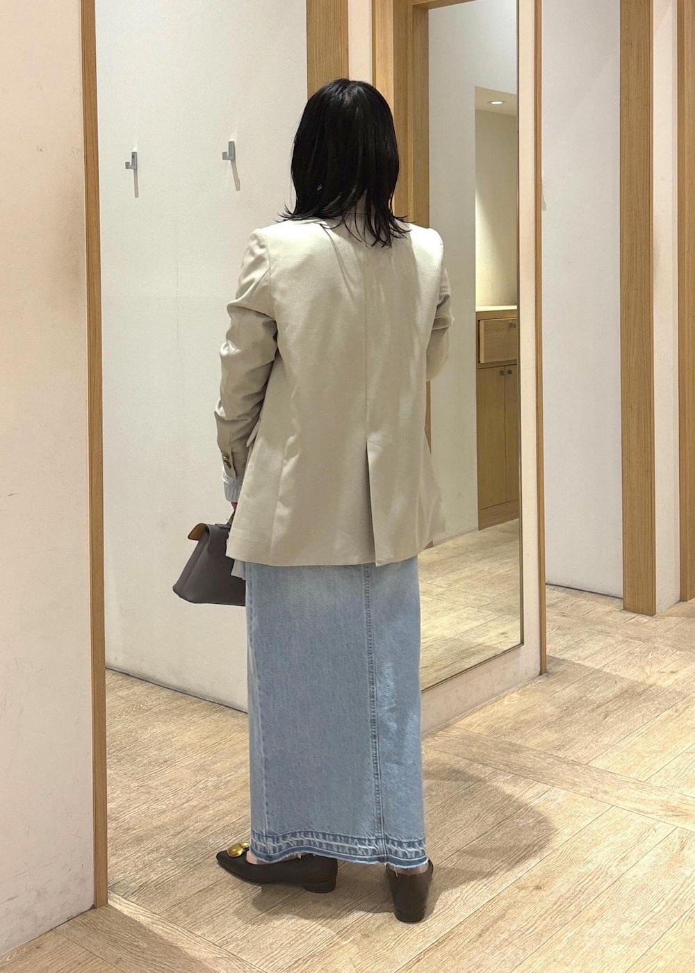グレー系のショルダーバッグ、ブラック系のバレエシューズ、ブルー系のデニムスカートを着用したレディースの冬コーディネートの4枚目の写真