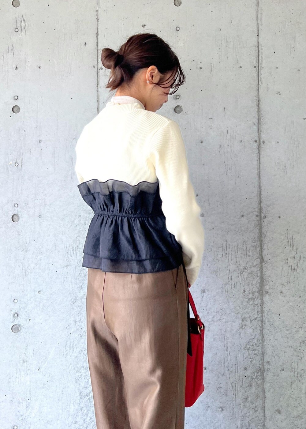 レッド系のショルダーバッグ、ブラック系のパンプス、ホワイト系のニット/セーターを着用したレディースの冬コーディネートの8枚目の写真