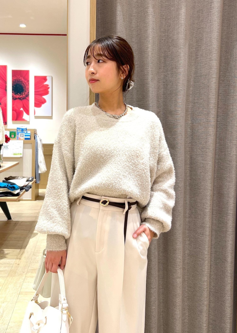 シルバー系のパンプス、ベージュ系のニット/セーター、ホワイト系のスラックスを着用したレディースの冬コーディネートの5枚目の写真