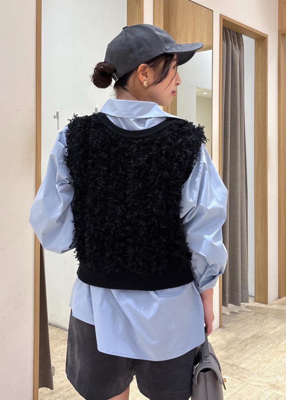 グレー系のショルダーバッグ、ブルー系のシャツ/ブラウス、ブラック系のベストを着用したレディースの秋コーディネートの7枚目の写真