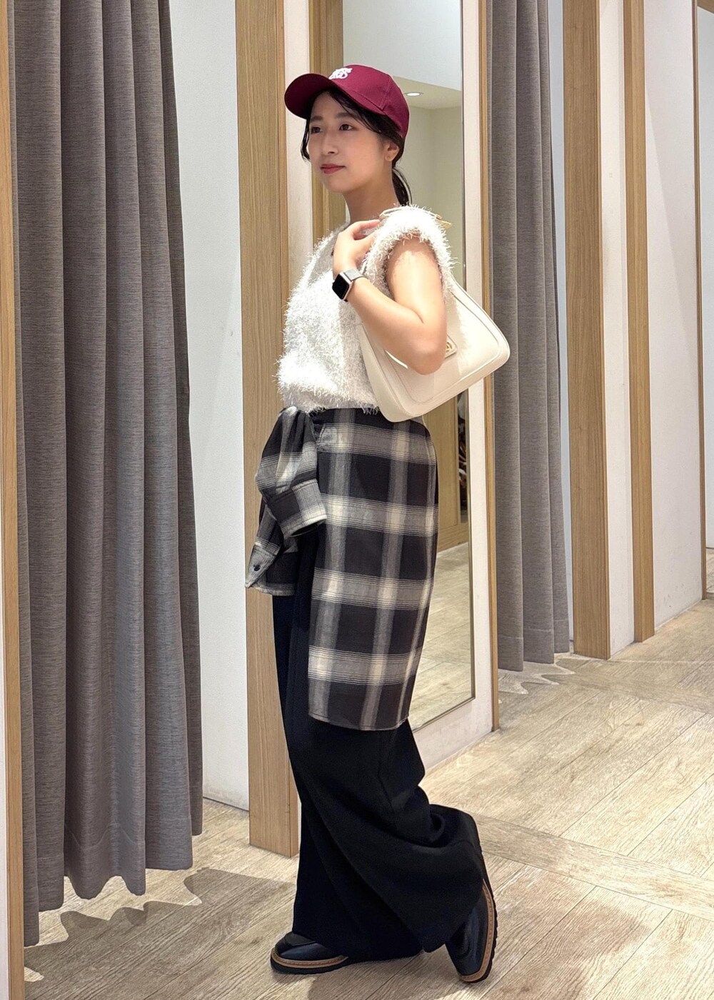 ホワイト系のショルダーバッグ、ホワイト系のニット/セーター、ブラック系のシャツ/ブラウスを着用したレディースの秋コーディネートの2枚目の写真