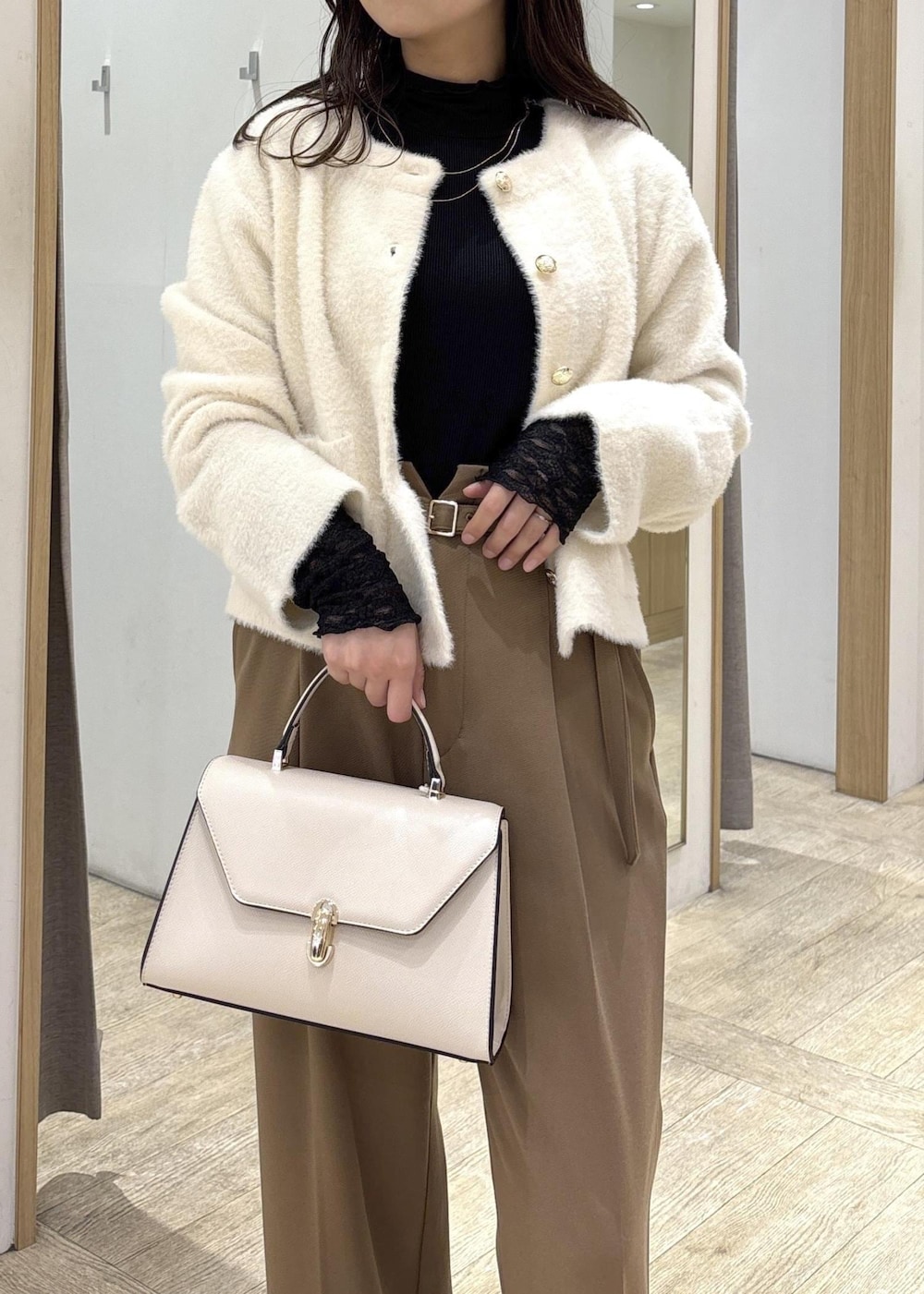 ホワイト系のカーディガン/ボレロ、ブラック系のTシャツ/カットソー、ブラック系のブーツを着用したレディースの秋コーディネートの6枚目の写真