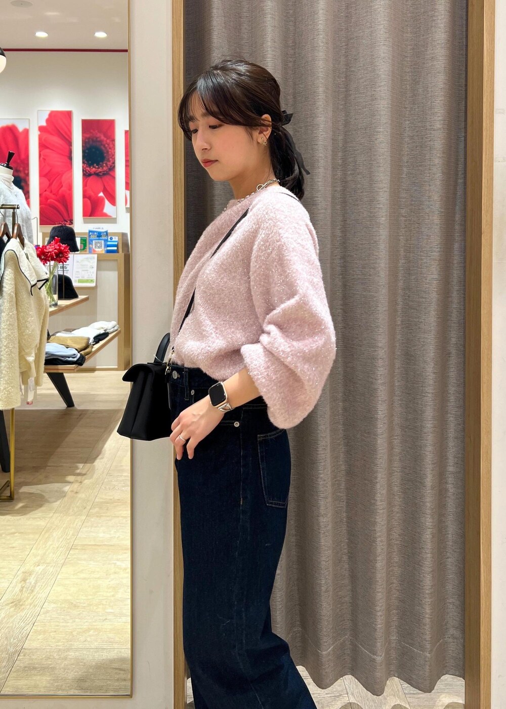 ブラック系のショルダーバッグ、シルバー系のブーツ、ブルー系のデニムパンツを着用したレディースの冬コーディネートの7枚目の写真