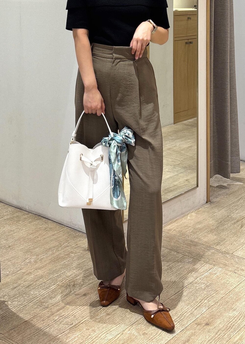 ホワイト系のショルダーバッグ、グリーン系のスラックス、ブラック系のニット/セーターを着用したレディースの夏コーディネートの9枚目の写真