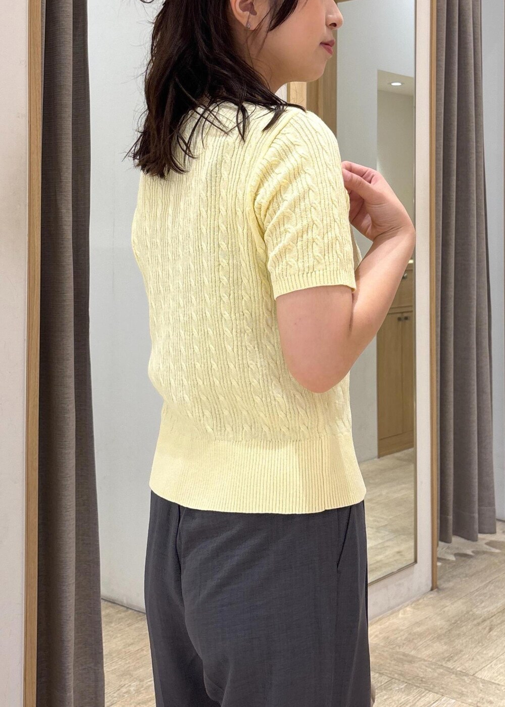 ベージュ系のショルダーバッグ、ブラック系のサンダル、グレー系のスラックスを着用したレディースの夏コーディネートの5枚目の写真