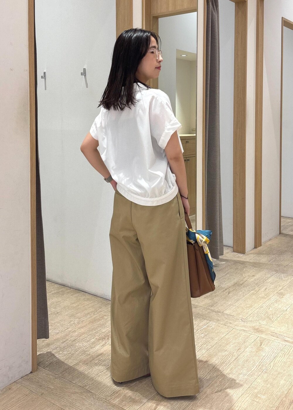 ブラウン系のショルダーバッグ、レッド系のサンダル、ホワイト系のシャツ/ブラウスを着用したレディースの夏コーディネートの3枚目の写真