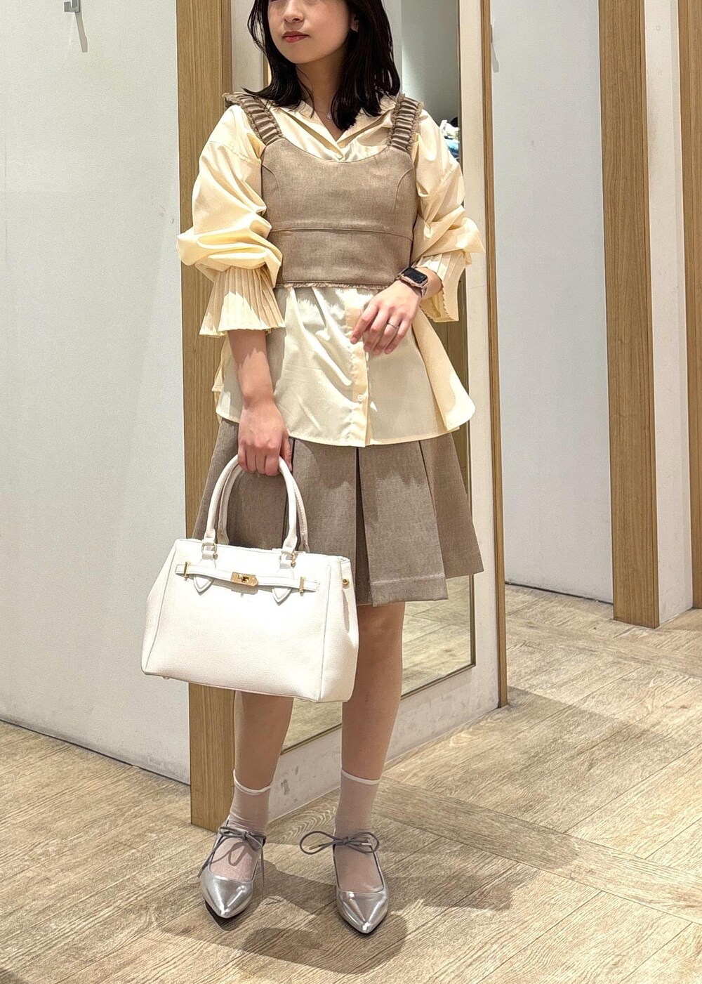 ホワイト系のショルダーバッグ、イエロー系のその他パンツ、イエロー系のベストを着用したレディースの春コーディネートの2枚目の写真