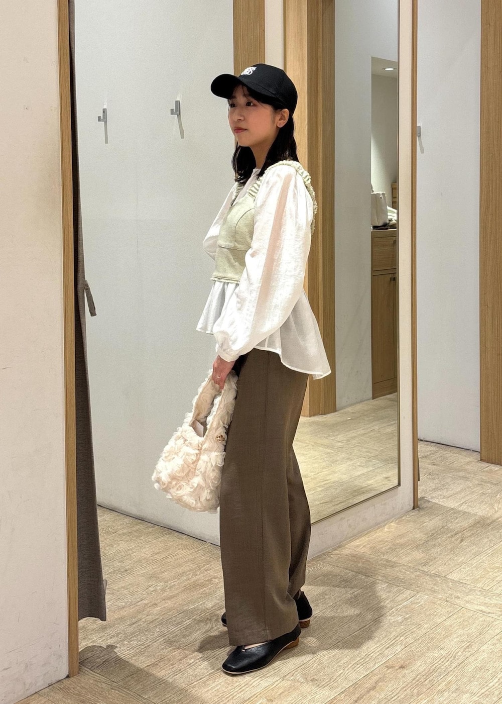 ホワイト系のシャツ/ブラウス、ブラック系のパンプス、ホワイト系のベストを着用したレディースの春コーディネートの2枚目の写真