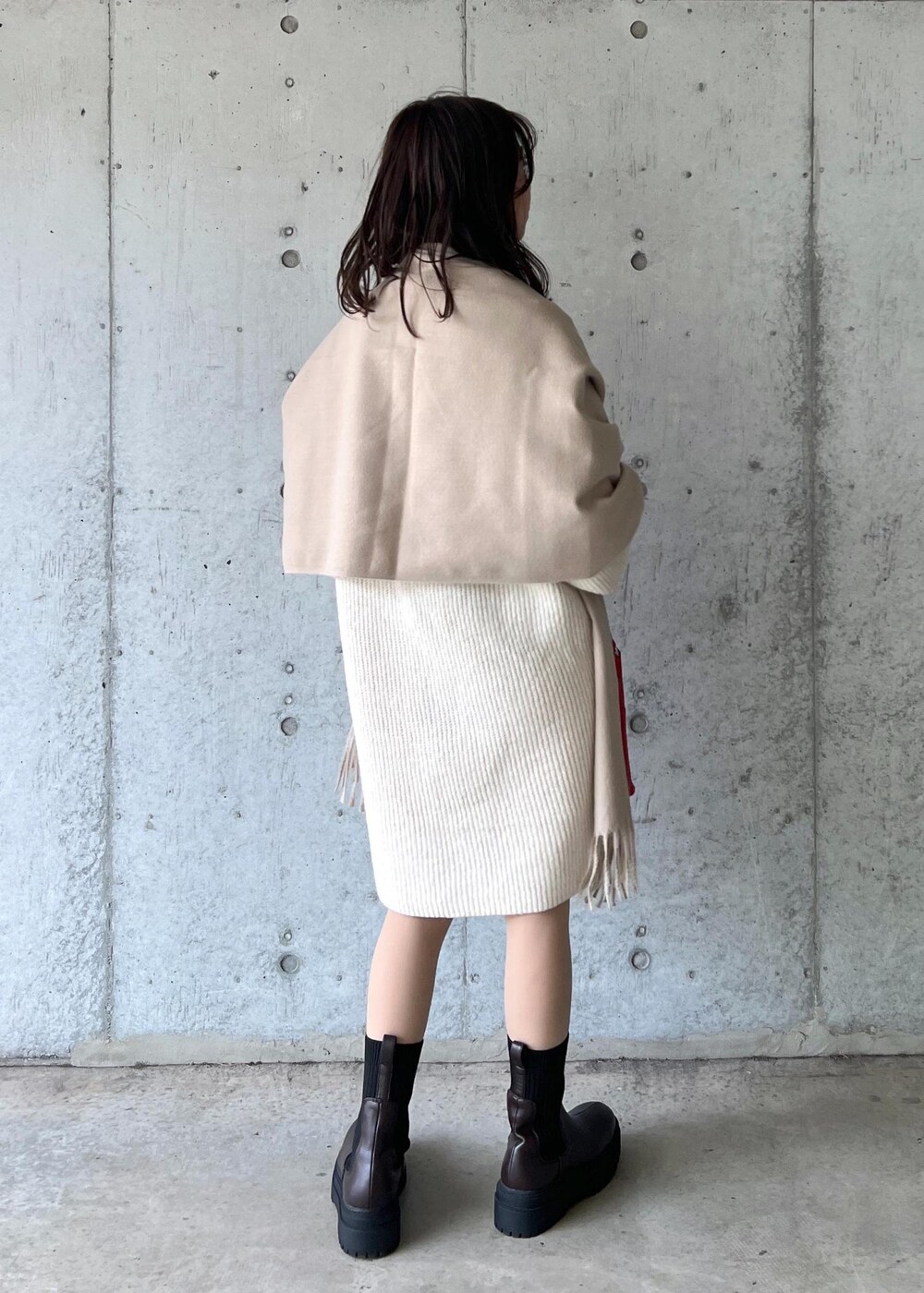 ブラウン系のブーツ、レッド系のショルダーバッグ、ホワイト系のワンピースを着用したレディースの冬コーディネートの4枚目の写真