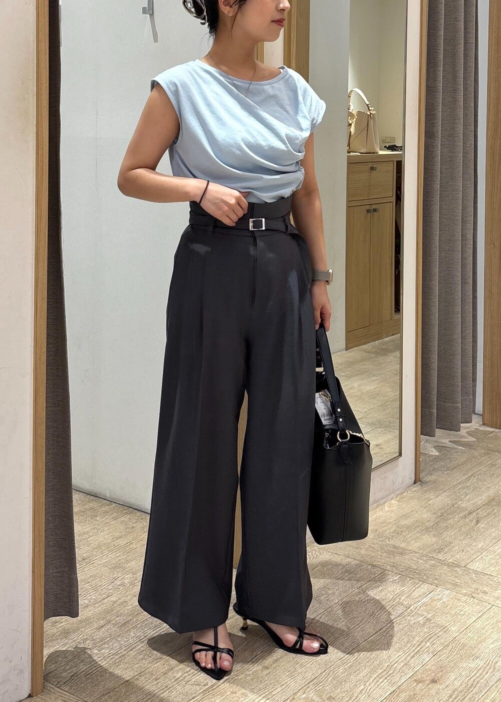 ブラック系のサンダル、ブルー系のTシャツ/カットソー、グレー系のスラックスを着用したレディースの夏コーディネートの2枚目の写真