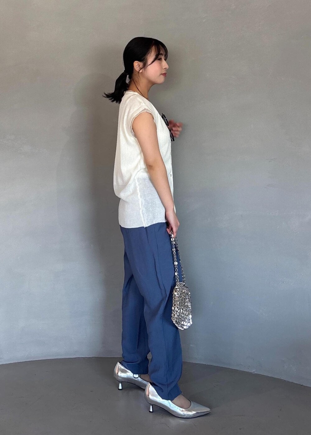 シルバー系のパンプス、ブルー系のその他パンツ、ホワイト系のベストを着用したレディースの春コーディネートの3枚目の写真