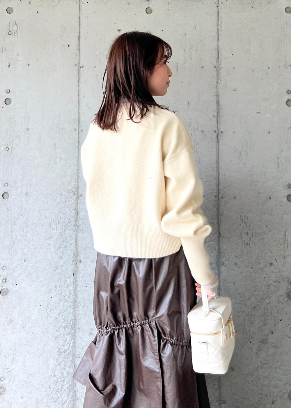 ブラウン系のスカート、ベージュ系のTシャツ/カットソー、ブラック系のパンプスを着用したレディースの冬コーディネートの9枚目の写真