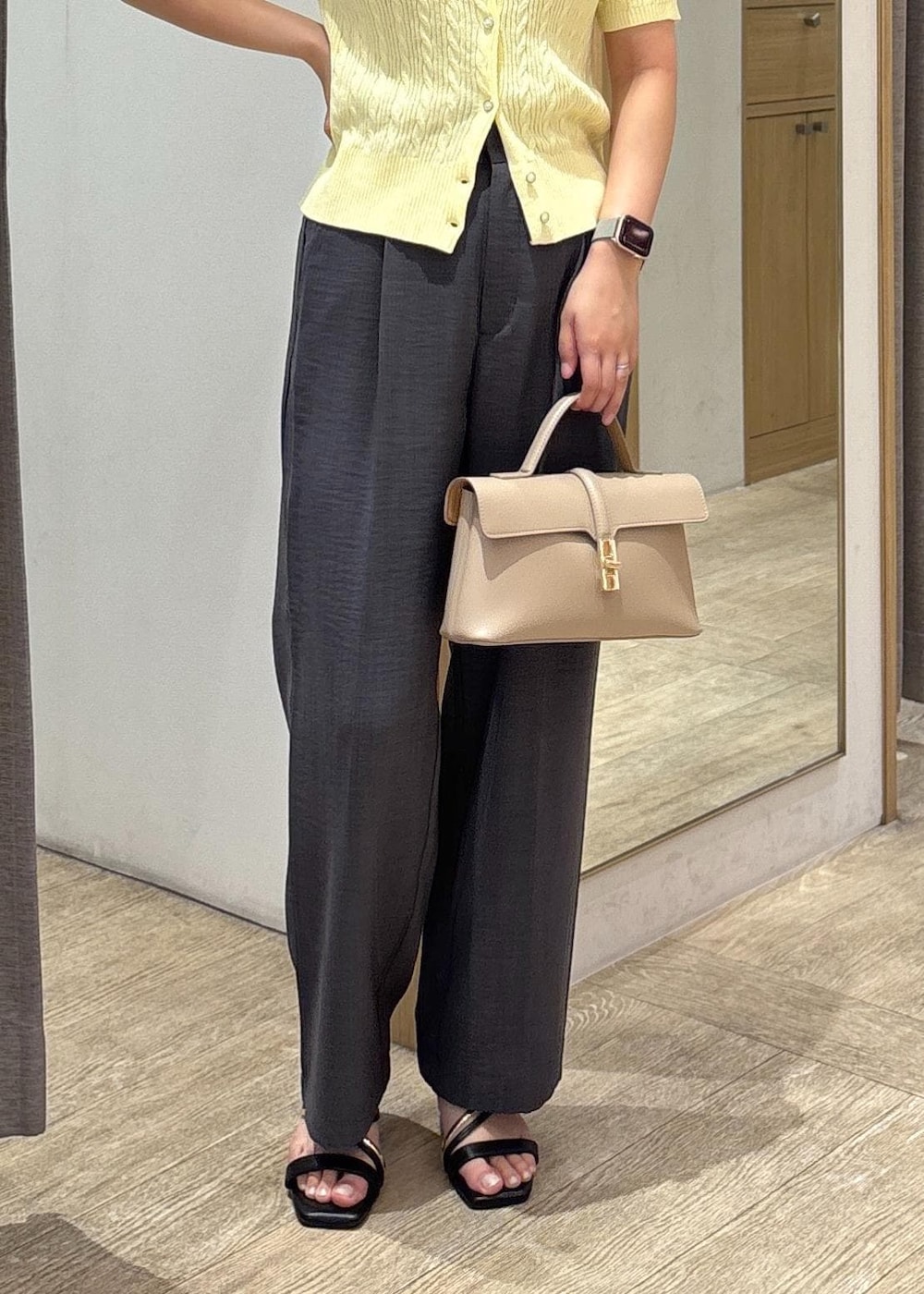 ベージュ系のショルダーバッグ、ブラック系のサンダル、グレー系のスラックスを着用したレディースの夏コーディネートの8枚目の写真