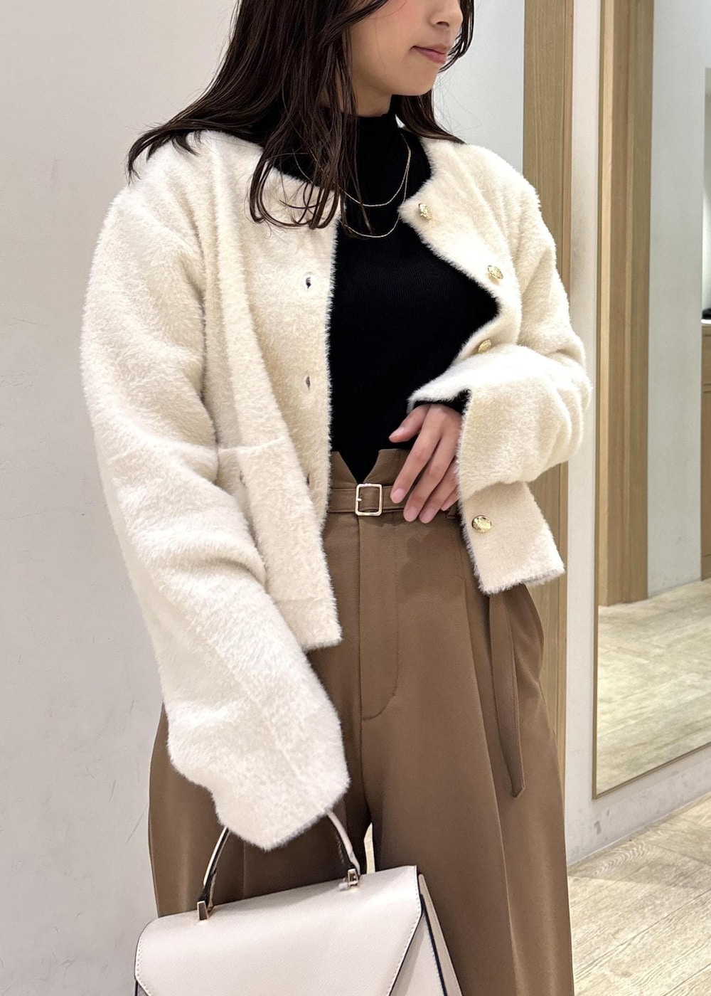 ホワイト系のカーディガン/ボレロ、ブラック系のTシャツ/カットソー、ブラック系のブーツを着用したレディースの秋コーディネートの5枚目の写真