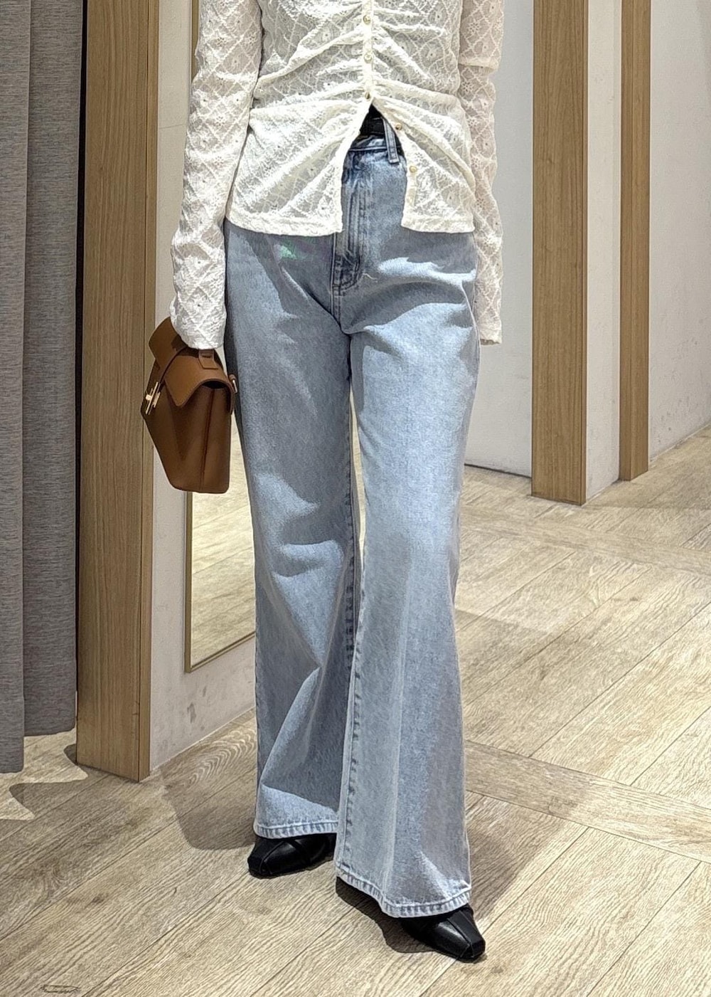 イエロー系のショルダーバッグ、ホワイト系のカーディガン/ボレロ、ブルー系のデニムパンツを着用したレディースの春コーディネートの9枚目の写真