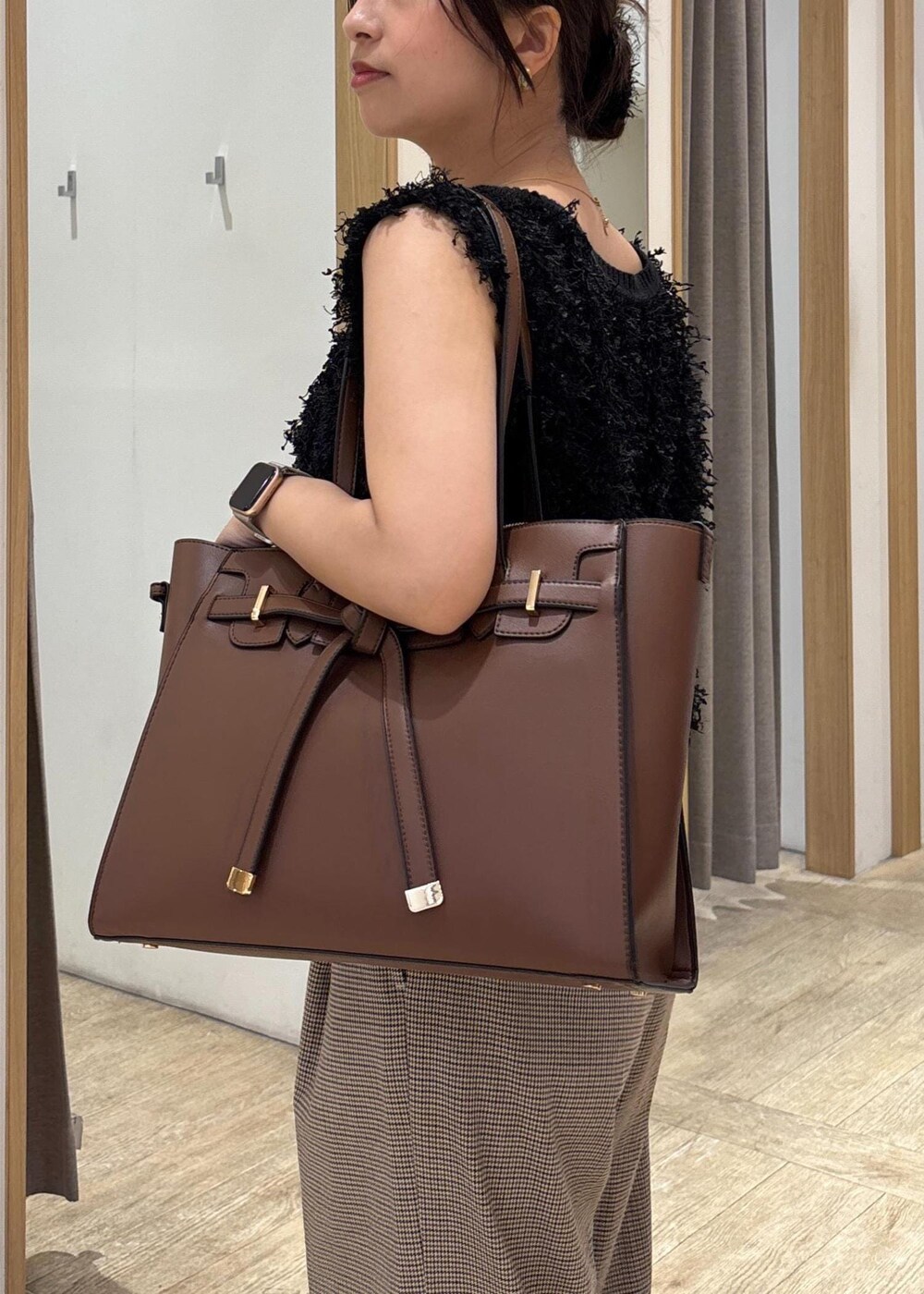 ブラック系のパンプス、ブラック系のベスト、ベージュ系のスラックスを着用したレディースの秋コーディネートの7枚目の写真