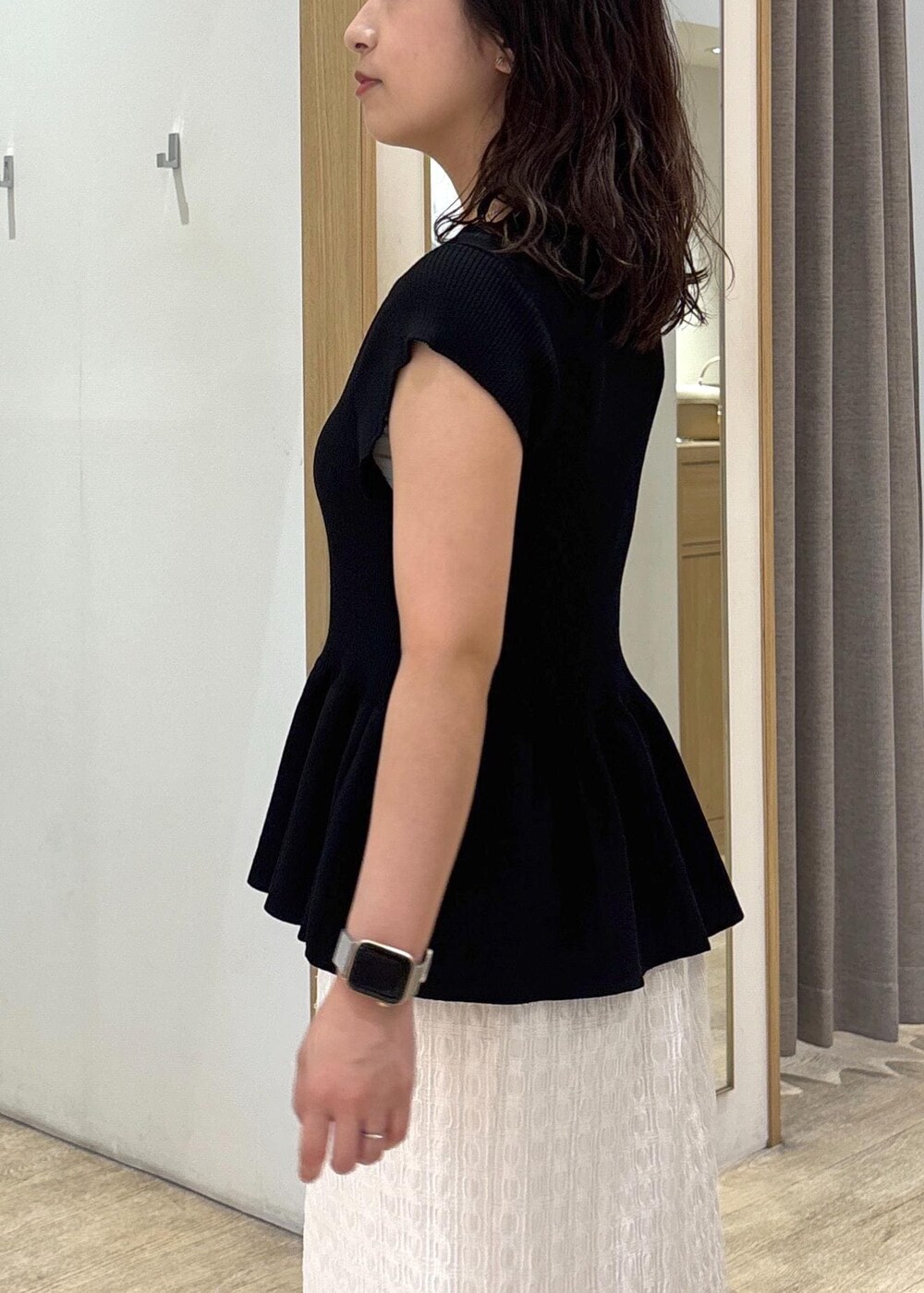 ブラック系のパンプス、ホワイト系のスカート、ブラック系のショルダーバッグを着用したレディースの夏コーディネートの6枚目の写真