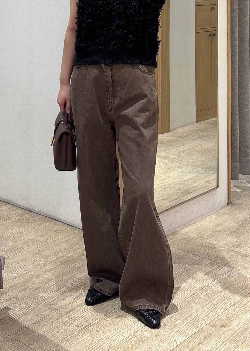 ブラウン系のショルダーバッグ、ブラック系のパンプス、ブラック系のベストを着用したレディースの秋コーディネートの8枚目の写真