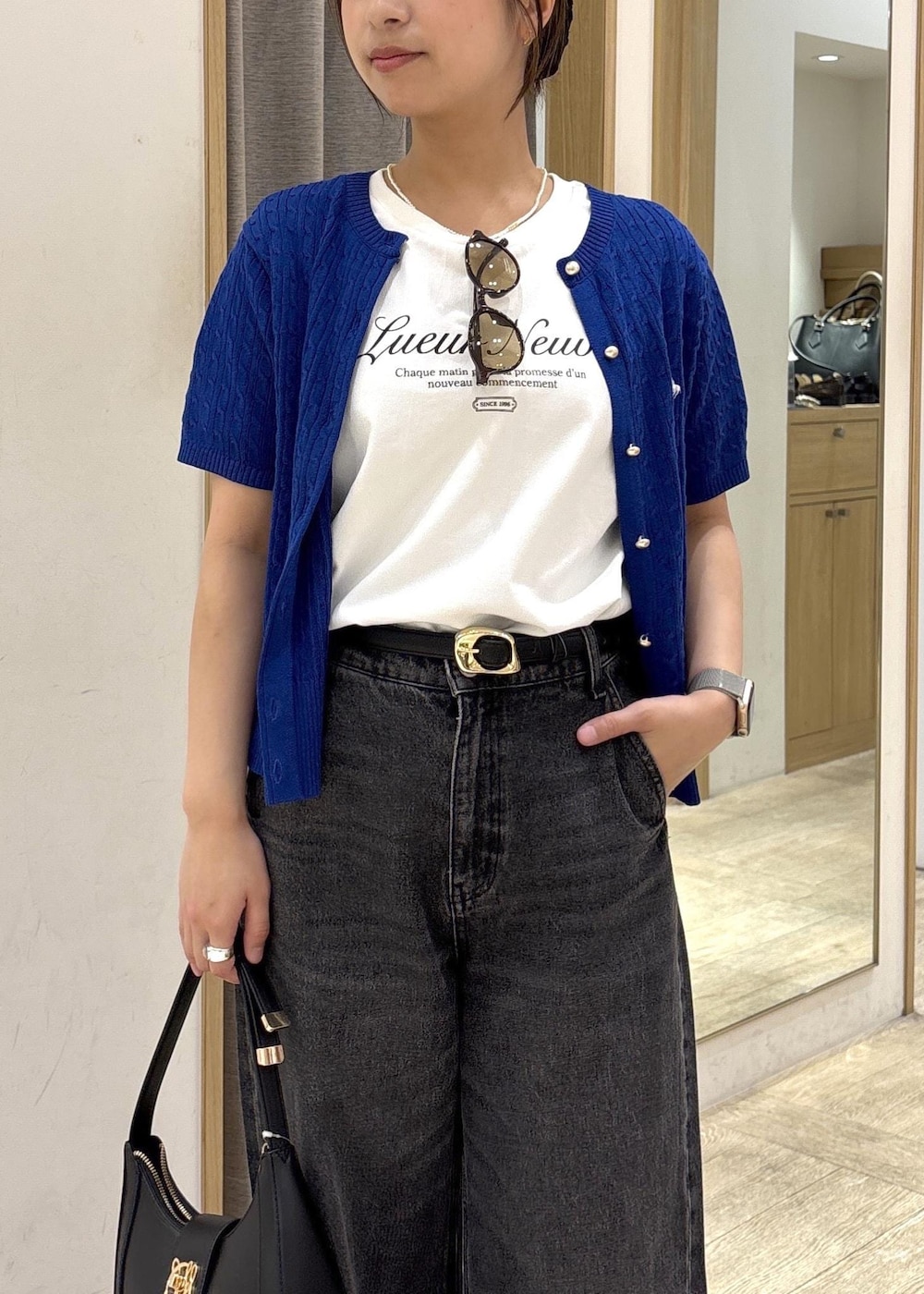 ブラック系のショルダーバッグ、ブラック系のデニムパンツ、ホワイト系のTシャツ/カットソーを着用したレディースの春コーディネートの6枚目の写真