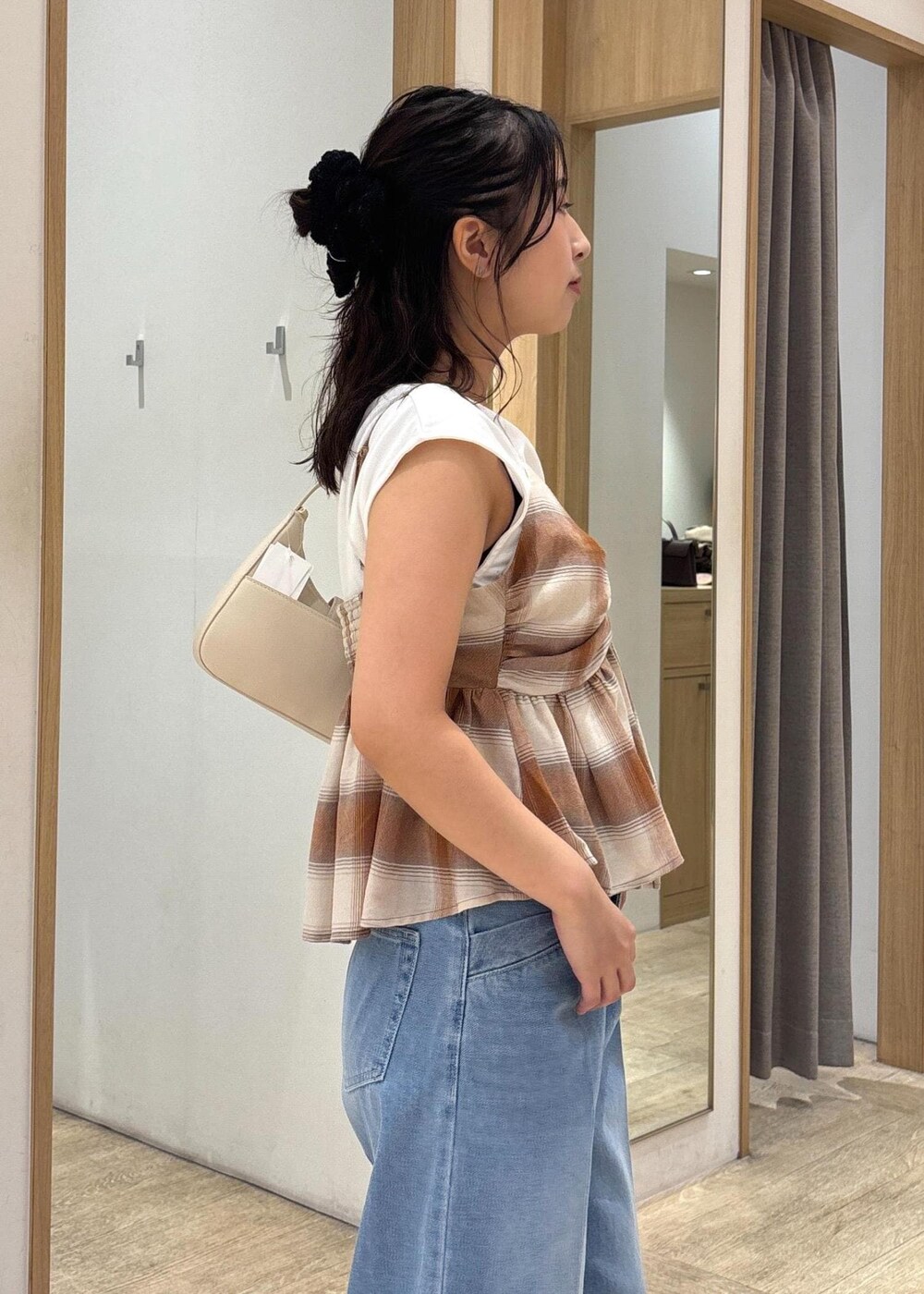 ブラック系のサンダル、ホワイト系のショルダーバッグ、ブルー系のデニムパンツを着用したレディースの夏コーディネートの6枚目の写真