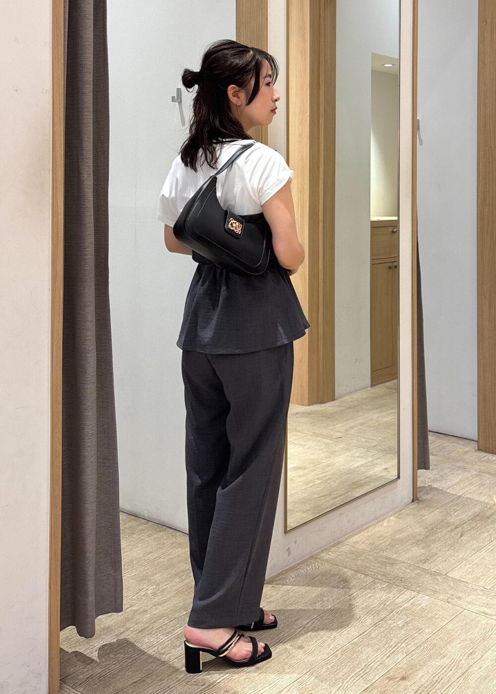 ブラック系のサンダル、グレー系のTシャツ/カットソー、グレー系のスラックスを着用したレディースの夏コーディネートの4枚目の写真