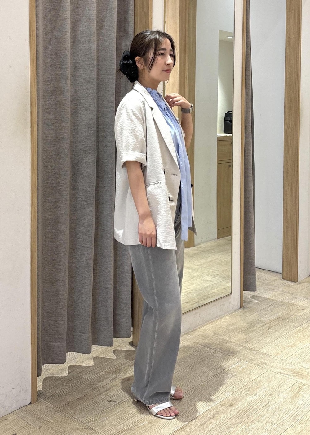 ブラック系のトートバッグ、ホワイト系のテーラードジャケット、グレー系のデニムパンツを着用したレディースの夏コーディネートの2枚目の写真