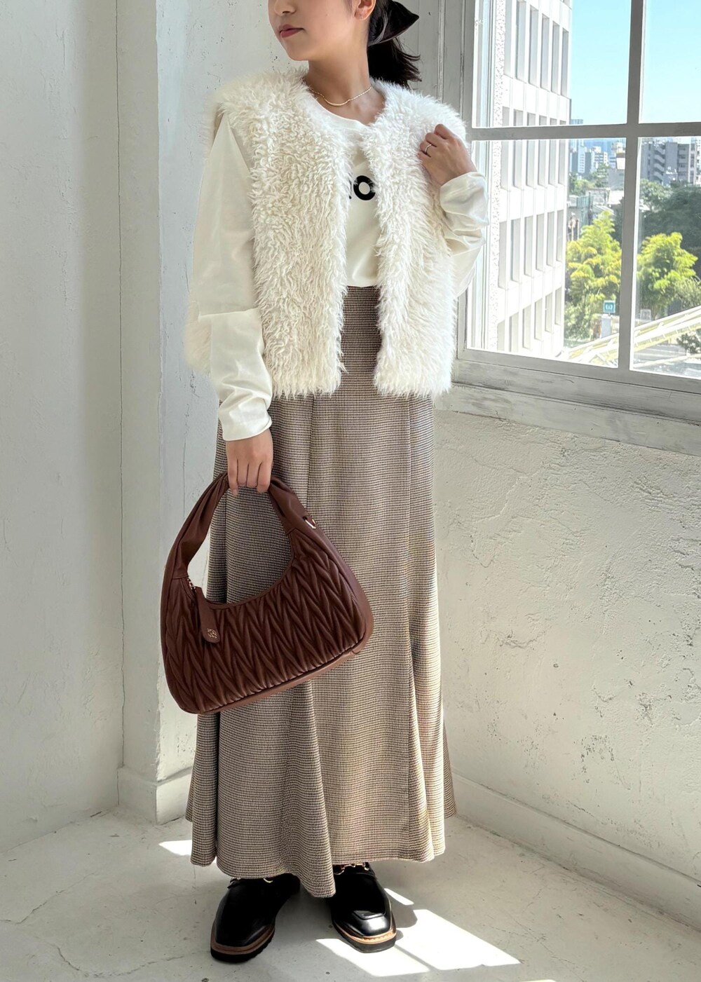 ブラック系のローファー、ベージュ系のスカート、ホワイト系のTシャツ/カットソーを着用したレディースの夏コーディネートの9枚目の写真