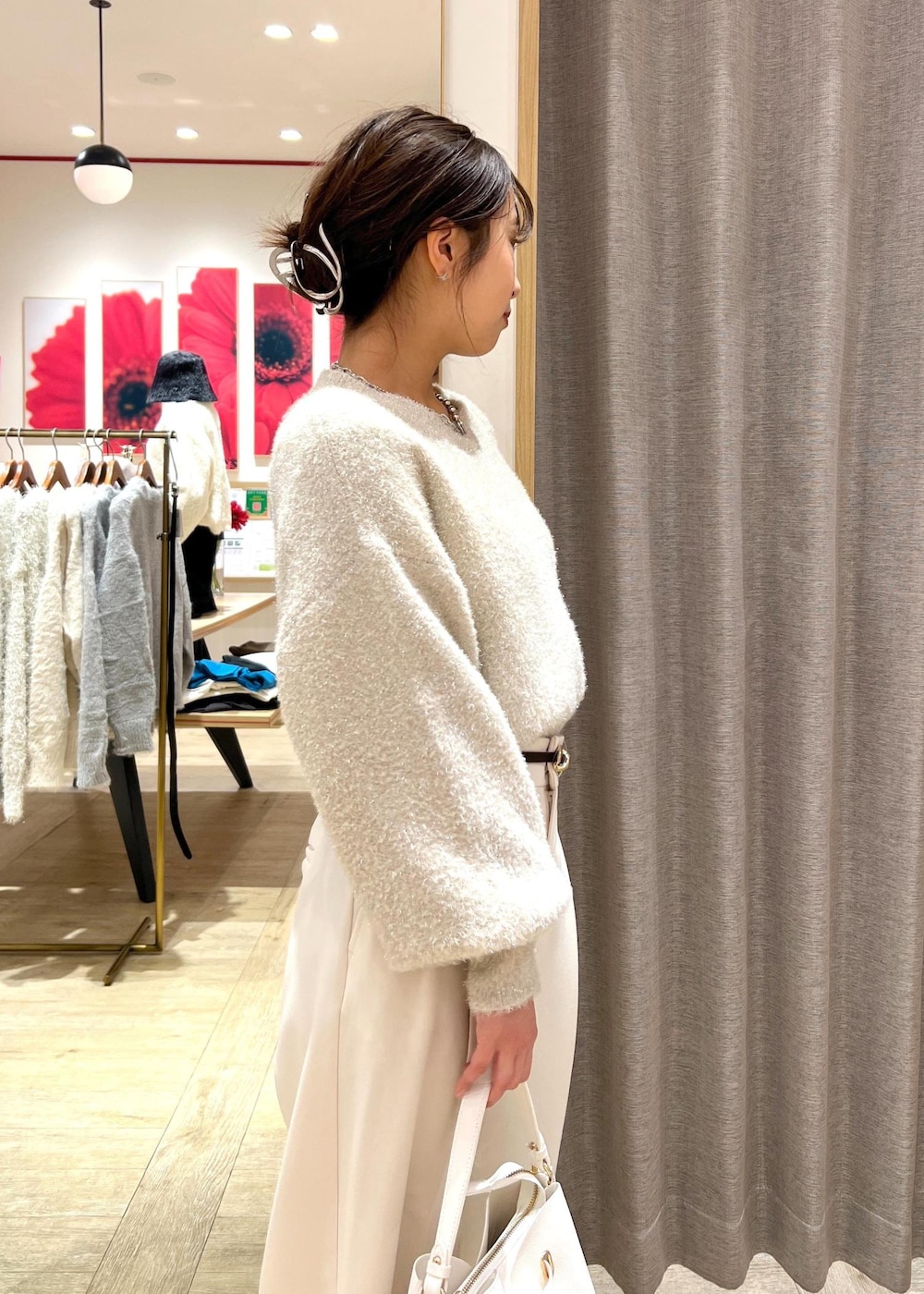 シルバー系のパンプス、ベージュ系のニット/セーター、ホワイト系のスラックスを着用したレディースの冬コーディネートの8枚目の写真