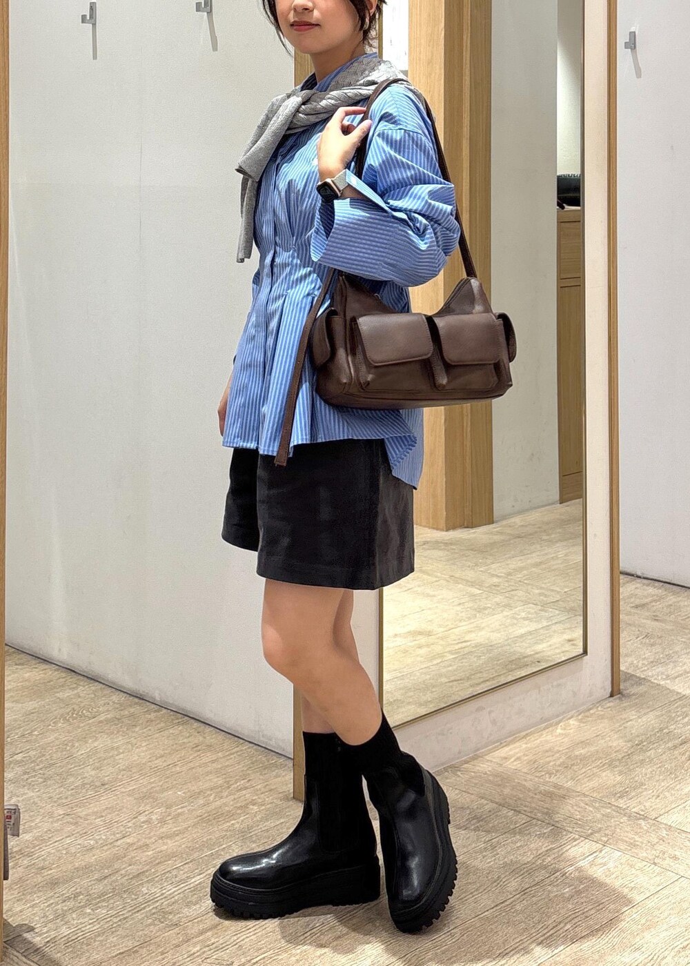 ブラック系のブーツ、ブルー系のシャツ/ブラウス、グレー系のカーディガン/ボレロを着用したレディースの秋コーディネートの4枚目の写真